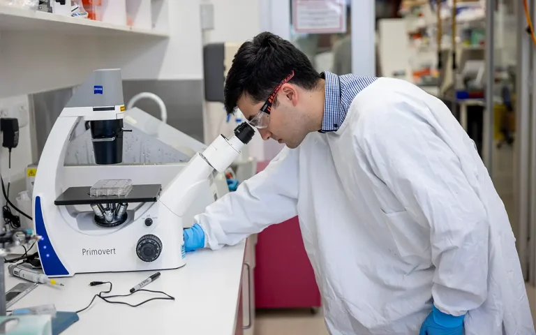 Student Researcher Matthew Taper examines specimens under the microscope